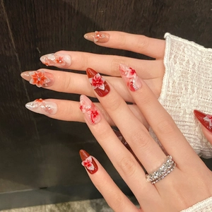 Handmade press-on nails with 3D floral relief, orange gradient, and glitter diamonds