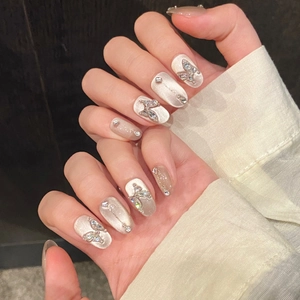 Exquisite silver cat eye press-on nails featuring 3D butterfly charms and rhinestones