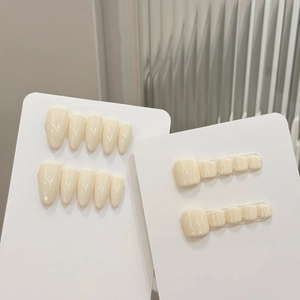Almond shaped fingernails and square toenails set in glossy creamy white finish