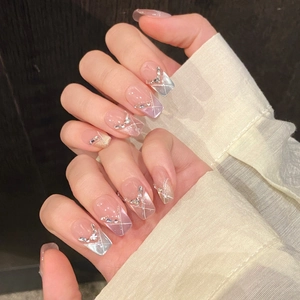 Pink cat eye press-on nails with white geometric lines and sparkling rhinestones