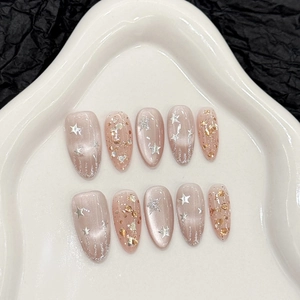 Star and moon themed press-on nails with cat-eye base and champagne gold glitter