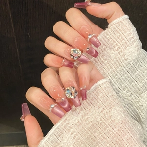 Detail of long coffin press-on nails with purple gradient, cat eye finish and rhinestones