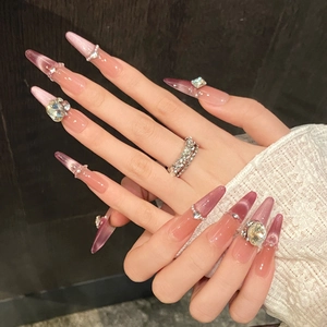 Close-up of purple gradient cat-eye stiletto press-on nails with rhinestones and pearls