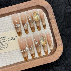 Handmade cat eye press-on nails with golden gradient finish and yellow rhinestones