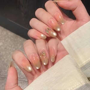 Pink and champagne gradient cat-eye press-on nails with 3D butterfly rhinestone detail