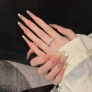 Long pointed press-on nails with pink gradient, zircon butterflies, and cat-eye finish