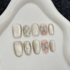 Handmade cat-eye press-on nails with argyle patterns and delicate bow jewelry accents