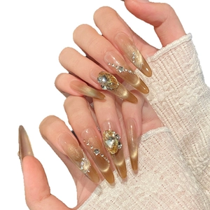 Handmade almond press-on nails with amber cat-eye gradient and sparkling rhinestones
