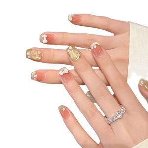 French gradient press-on nails with 3D floral and bow designs in orange-pink tones