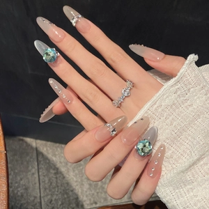 Handmade almond cat-eye press-on nails with blue square gems and silver rhinestone accents