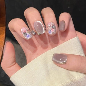 Short square press-on nails featuring purple cat-eye finish with dried flowers and pearls