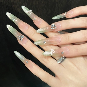Long stiletto press-on nails with green cat eye gradient and 3D white bows