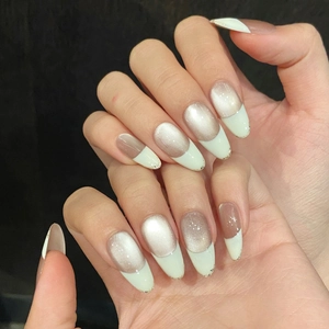 Elegant long almond cat-eye press-on nails with white French tips and gold glitter