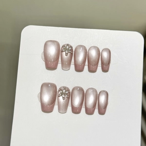 Pink cat eye press-on nails with floral rhinestone accents and iridescent aurora finish
