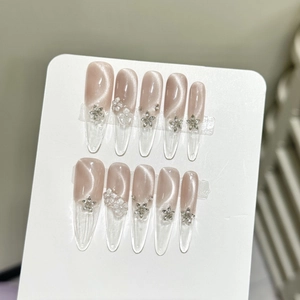 Handmade almond press-on nails featuring pink cat-eye effect and 3D floral accents