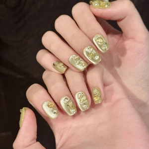 Olive green cat eye press-on nails with golden foil and yellow crystal gravel accents