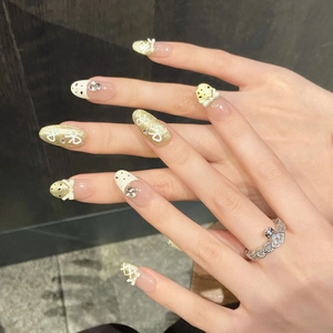 French bow press-on nails with cream white relief and sparkling gold glitter finish