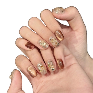 Brown cat-eye press-on nails with gold foil sequins and luxury crystal stone details