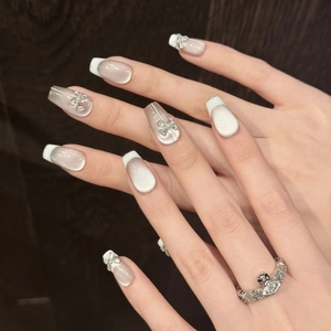 Cat eye press-on nails with French white tips and sparkling 3D rhinestone bows