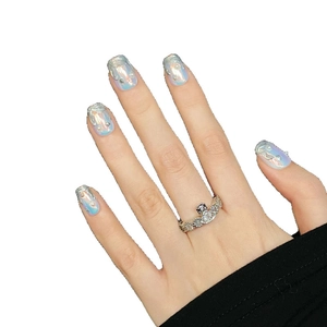 Faux ongles aurore métallisée avec textures 3D et perles sur fond blanc