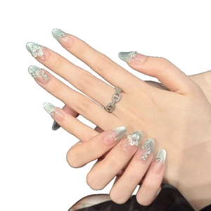 Handmade mint green cat eye press-on nails with 3D white floral and pearl accents