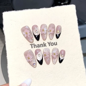 Detailed view of pink cat-eye press-on nails with 3D floral carving and rhinestones