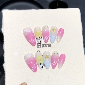 Detail of long almond press-on nails with 3D yellow flowers, pearls and pink gradient