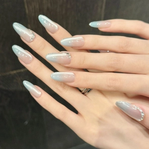 Unghie finte occhio di gatto blu con sfumatura glitter e strass su forma ovale lunga