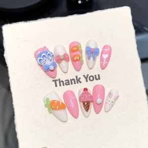 Gros plan de faux ongles faits main rose et blanc avec des breloques lapin et nœud 3D