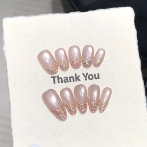 Detail of pink pearlescent handmade nails with glitter French tips on a display card