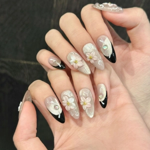 Pink cat-eye press-on nails with 3D embossed flowers and French black tips design