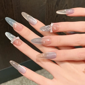 Long almond cat-eye press-on nails with 3D relief bows and pearls in icy blue gradient
