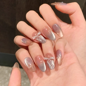 Pink cat eye press-on nails with 3D bow and water drop charms for a fresh summer look