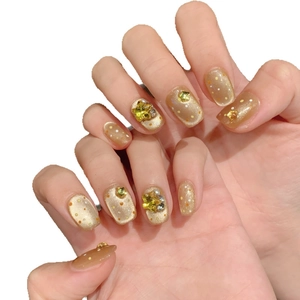 Golden cat eye press-on nails with star rhinestones and orange polka dot design