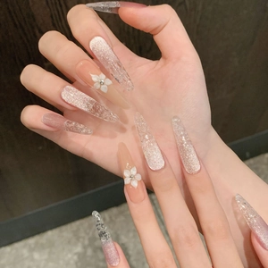 Pink cat-eye press-on nails with 3D white floral accents and sparkling rhinestone details