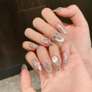 Cat-eye press-on nails with 3D flowers, pearls, and rhinestones in soft pink jelly finish