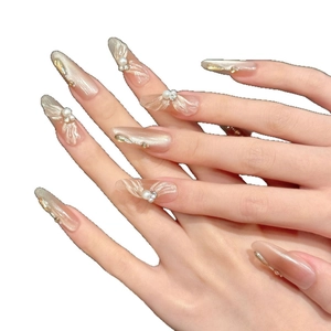 Long almond ballet core press-on nails with champagne ribbons and pearl accents