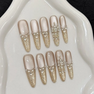 Champagne nude press-on nails with luxury gold glitter and crown rhinestone details