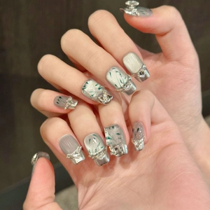 Silver cat-eye press-on nails with metal trim and sparkling rhinestones
