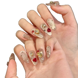 Cat eye press-on nails with red heart diamonds and gold stars on long almond shape