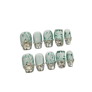 Short mint green press-on nails with bamboo leaf design and silver rhinestone accents