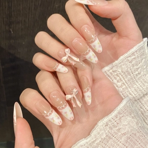 Long almond press-on nails with French white tips, floral patterns, and 3D bows