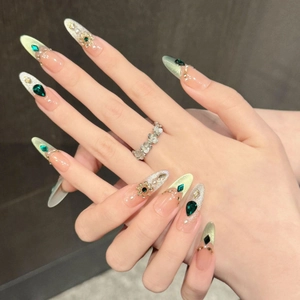Luxurious emerald almond press-on nails with cat-eye effect, pearls, and crystals