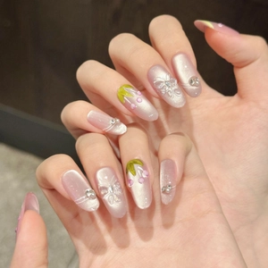 Pink cat-eye press-on nails with 3D butterflies and pearl accents on long oval shape