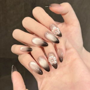 Long almond press-on nails with brown-black cat eye gradient and 3D floral accents
