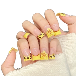 Yellow sakura press-on nails with 3D floral accents and gold beads in a french style