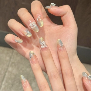 Blue cat eye press-on nails with 3D white flowers and pearl accents on almond shape