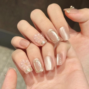Elegant nude pink press-on nails with 3D floral designs, pearls, and cat-eye glitter finish