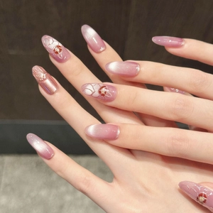 Pink gradient cat-eye press-on nails with 3D floral patterns and delicate bead accents