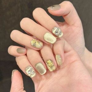 Cat eye press-on nails in champagne gold with 3D rhinestones and metallic textures